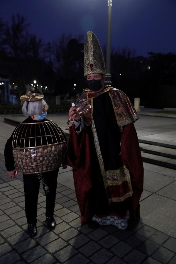 Dos entusiastas del Sorteo de Navidad disfrazados aguardan en las inmediaciones del Teatro Real antes del inicio del sorteo, este martes en Madrid. La ilusión vuelve a las nueve de esta mañana al Teatro Real de Madrid, que acoge un año más el Sorteo Extraordinario de la Lotería de Navidad, aunque este 2020 pasará a la historia por celebrarse sin público y con unas medidas especiales por el protocolo anticovid. EFE/J.J. Guillén