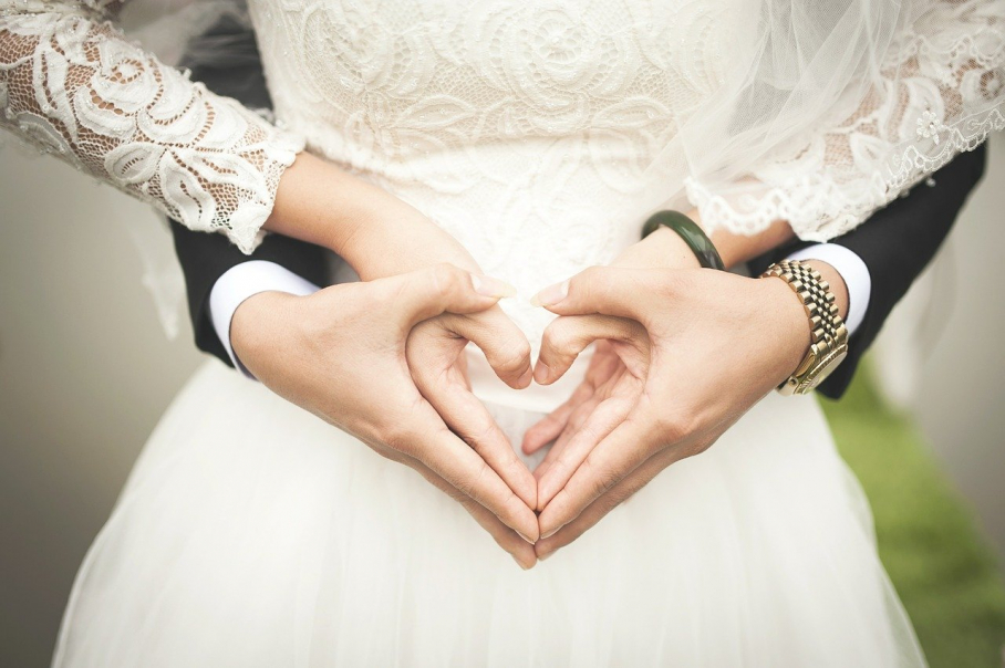 Dos novios realizan el gesto del corazón con sus manos
