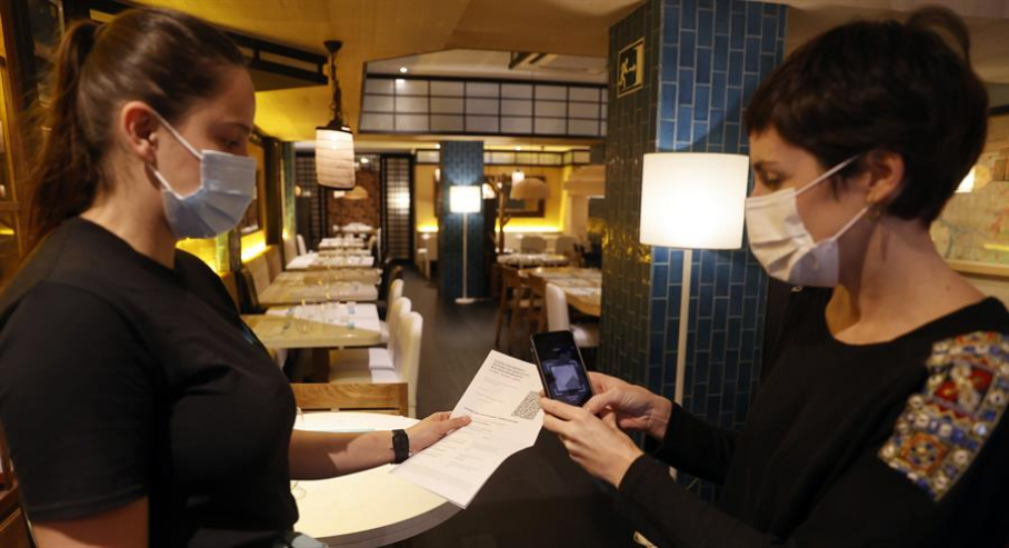 Una metre de un restaurante bilbaíno realiza una comprobación de un pasaporte Covid