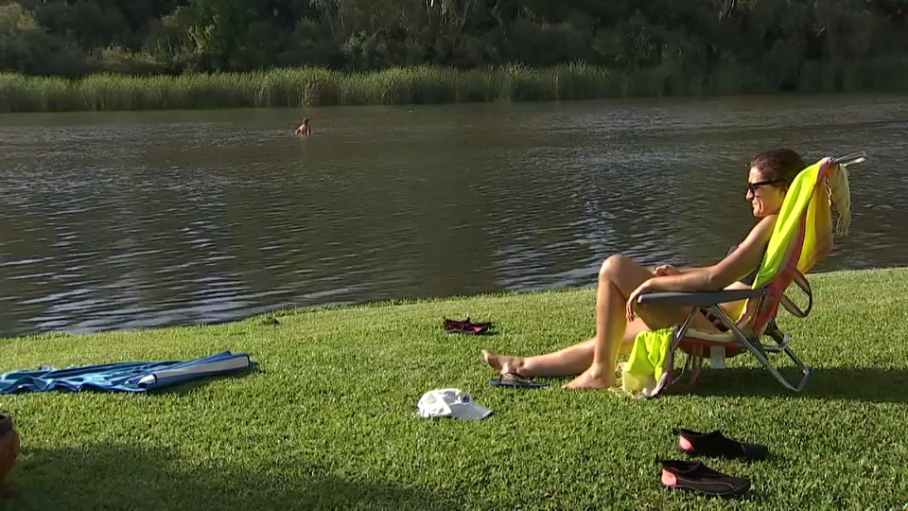 Mujer tomando el sol y refrescándose en la playa fluvial de Medellín