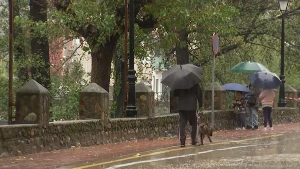 Personas paseando con paraguas durante la borrasca Claudia
