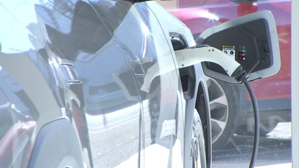 Un coche eléctrico cargándose dentro de un concesionario