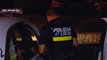 Un policía local vigila el ocio nocturno en un parque.