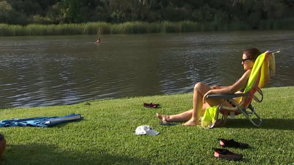 Mujer tomando el sol y refrescándose en la playa fluvial de Medellín