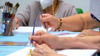 Manos de mujeres pintando con pincel