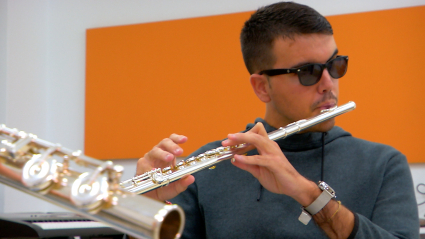 Alumno ciego de música tocando la flauta travesera