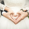 Dos novios realizan el gesto del corazón con sus manos