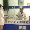 Dependienta atendiendo a clientes en una tienda de congelados