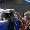 Empleado dando una mascarilla en una farmacia de Elvas
