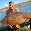 Jonathan Murillo Rubio junto a la carpa de casi 30 kilos que ha capturado en el embalse de Orellana