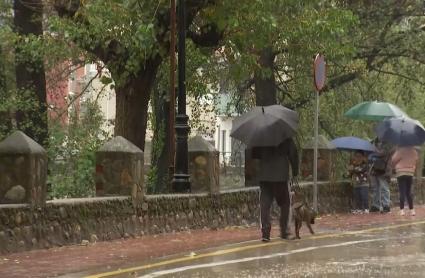 Personas paseando con paraguas durante la borrasca Claudia