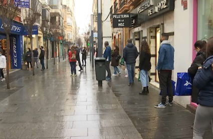 Clientes haciendo colas antes de la apertura de las tiendas en la calle Menacho de Badajoz