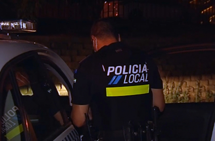 Un policía local vigila el ocio nocturno en un parque.