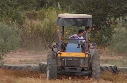 Joven agricultor con tractor en el campo.