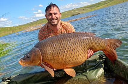 Jonathan Murillo Rubio junto a la carpa de casi 30 kilos que ha capturado en el embalse de Orellana