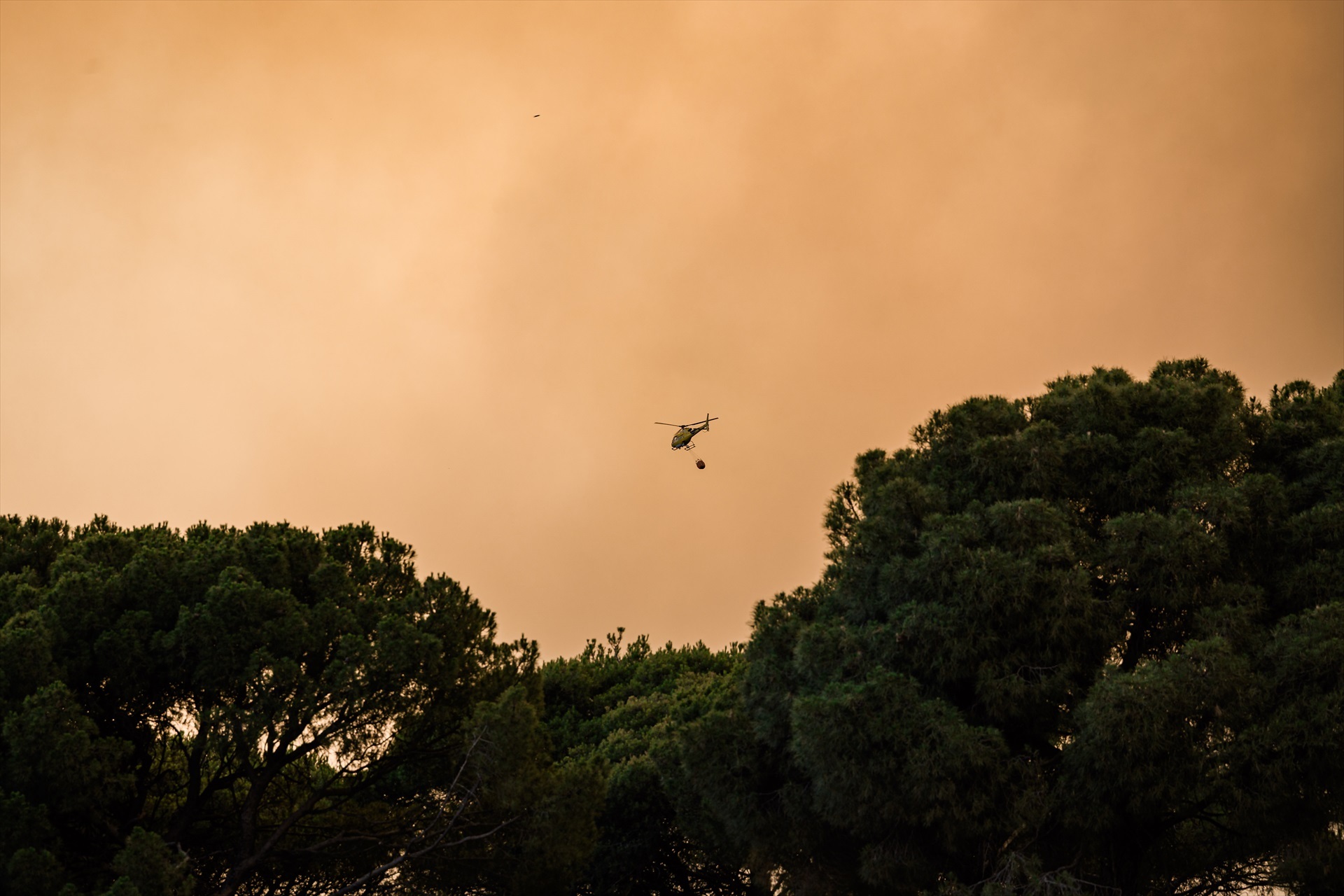 Un helicóptero colabora en la extinción del fuego, a 23 de julio de 2026, en San Martín de Valdeiglesias, Madrid