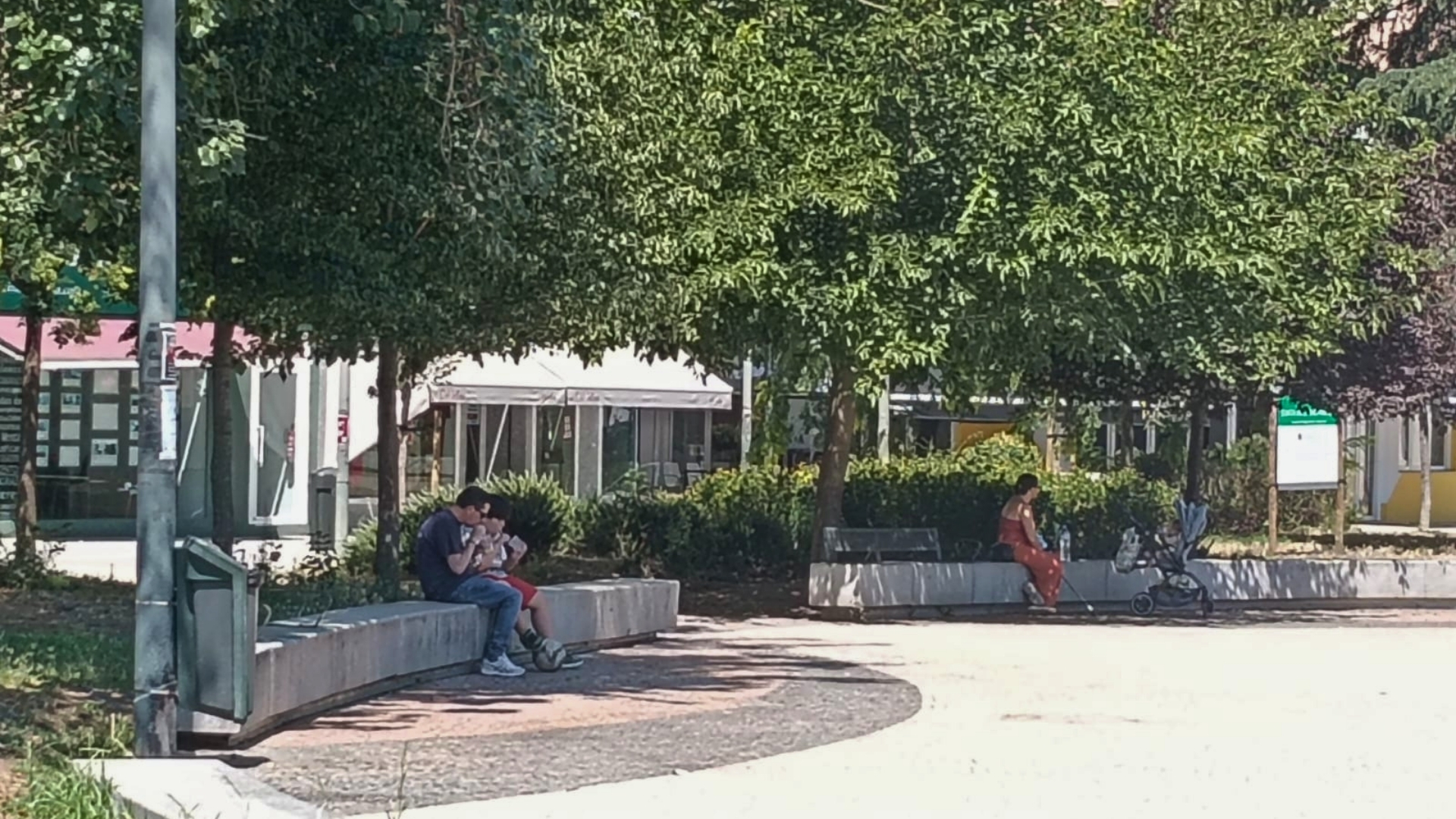Gente sentada a la sombra en un parque en Badajoz resguardándose del calor