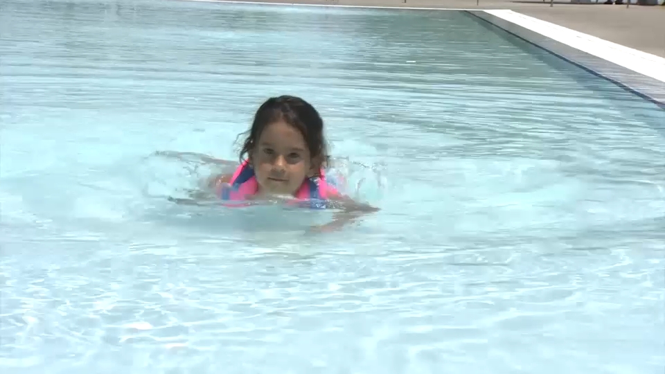 Niña con manguitos en una piscina