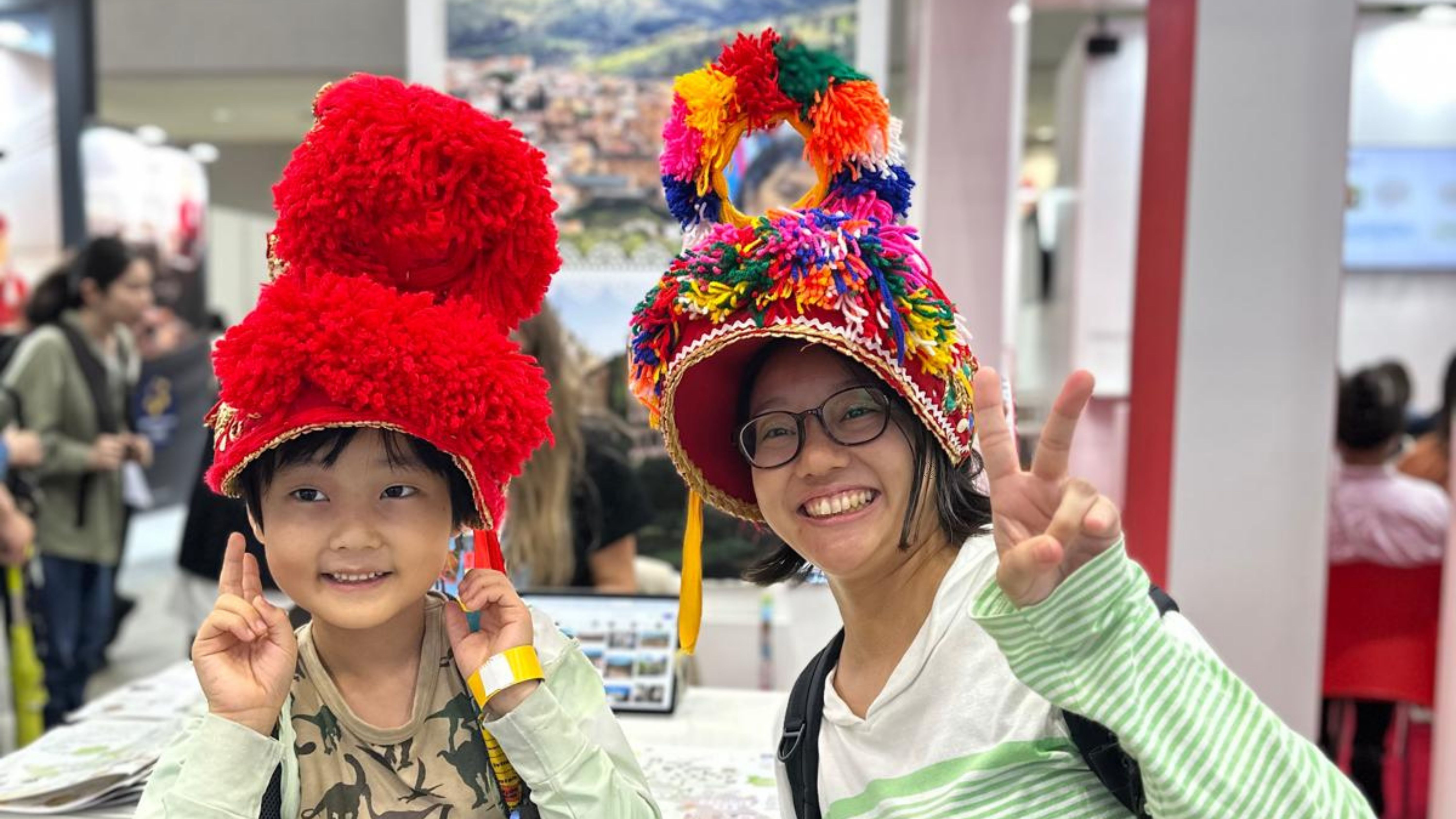 Dos japoneses con el gorro de montehermoseña en el stand de la Diputación en la Tourism Expo Japan, en Tokio. 