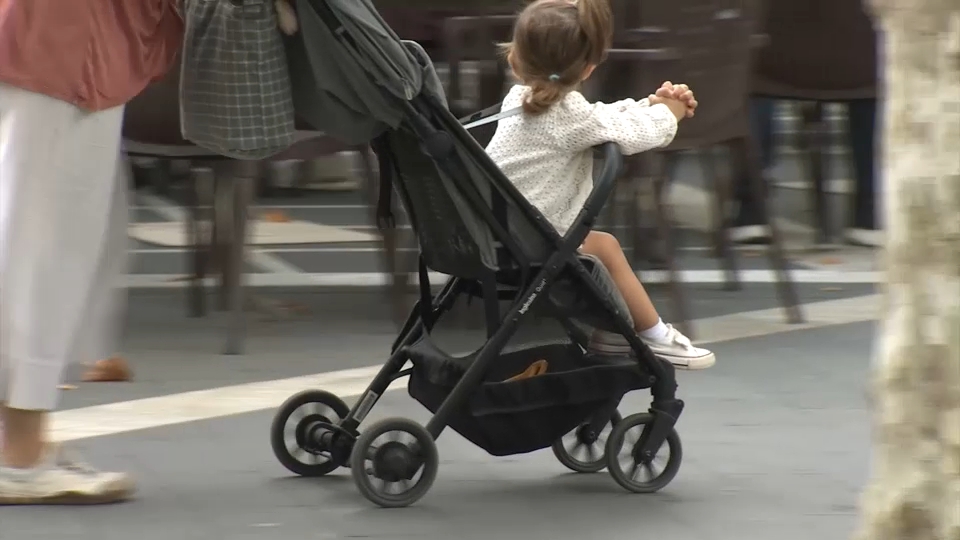 Niña pequeña en un carrito de bebé en una imagen de archivo
