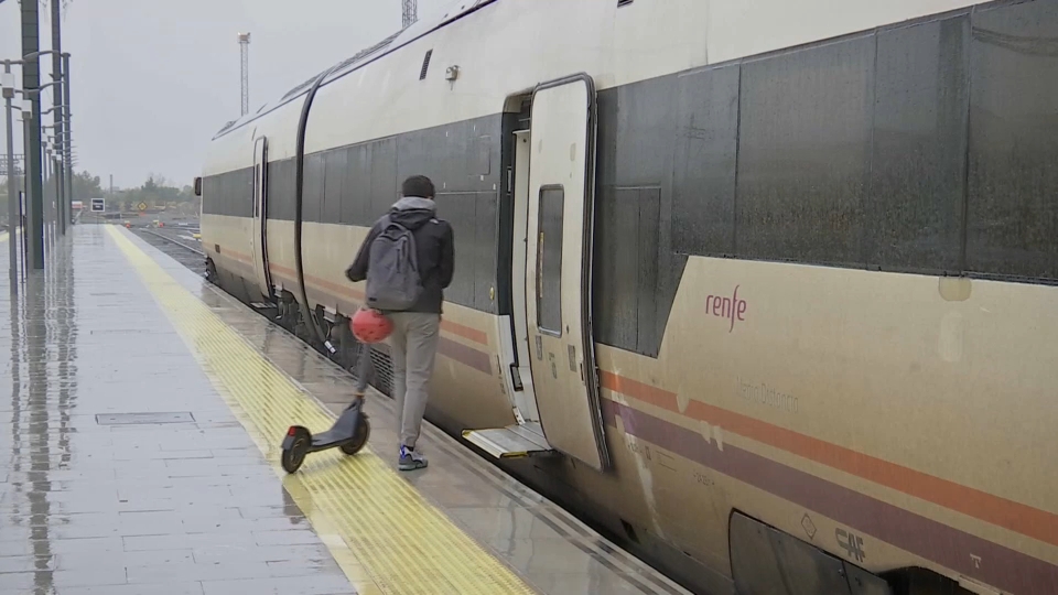 Usuario de Renfe entrando en el tren con un patinete en una imagen de archivo