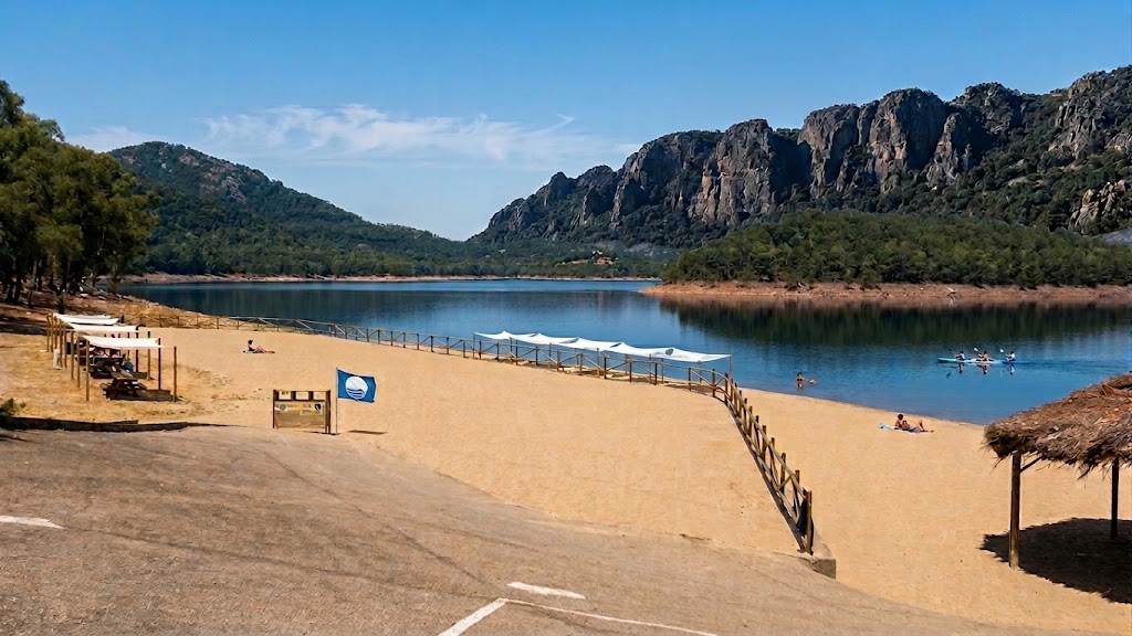 La playa de Bandera Azul de Puerto Peña, a orillas del embalse de García de Sola (Talarrubias), con el imponente trasfondo rocoso de la Gran Muralla.