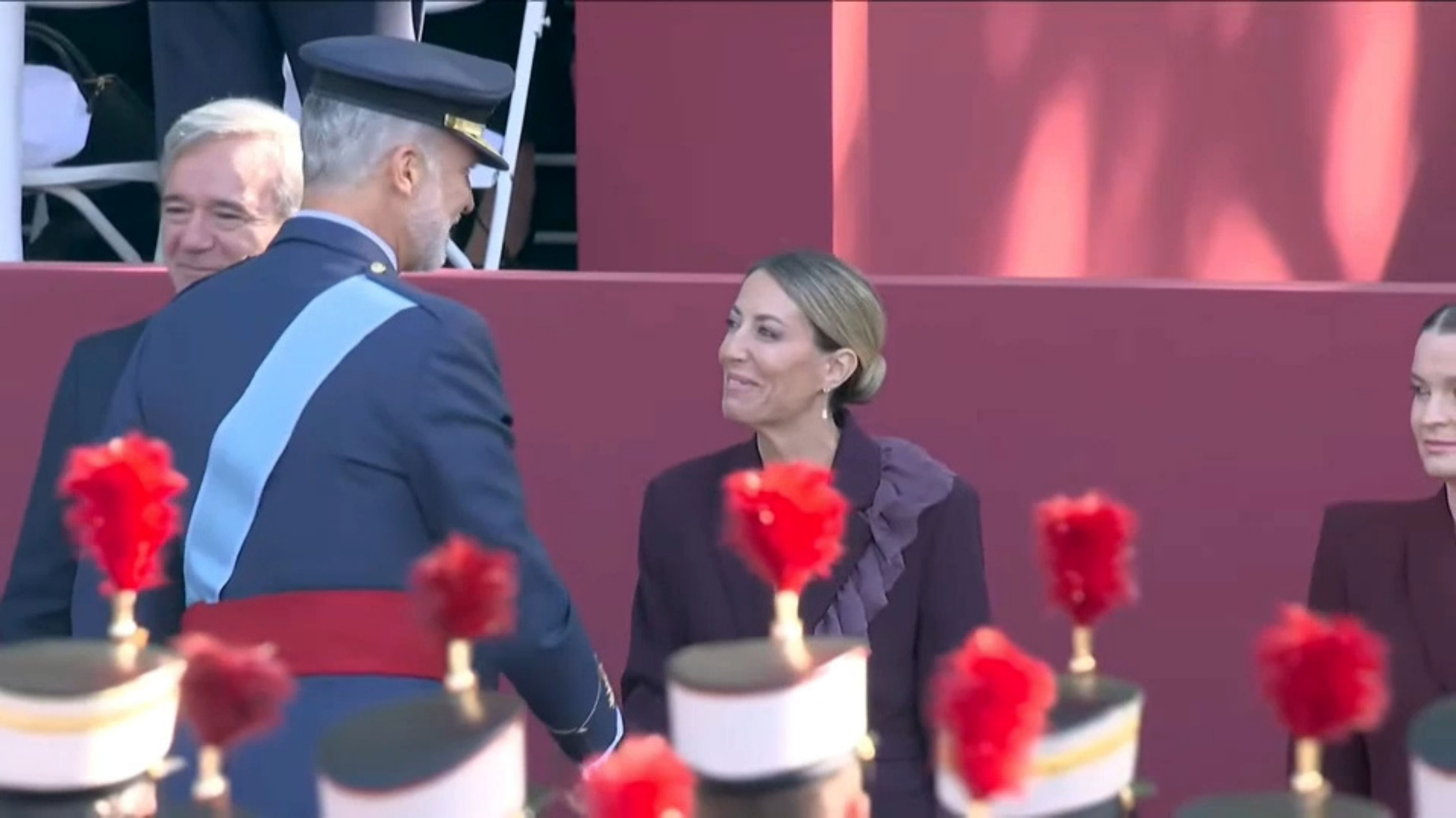 El Rey Felipe VI saluda a la presidenta de la Junta de Extremadura, María Guardiola, durante los actos conmemorativos de la Fiesta Nacional. 
