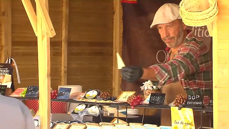 Un hombre, ofreciendo queso en un stand de la feria