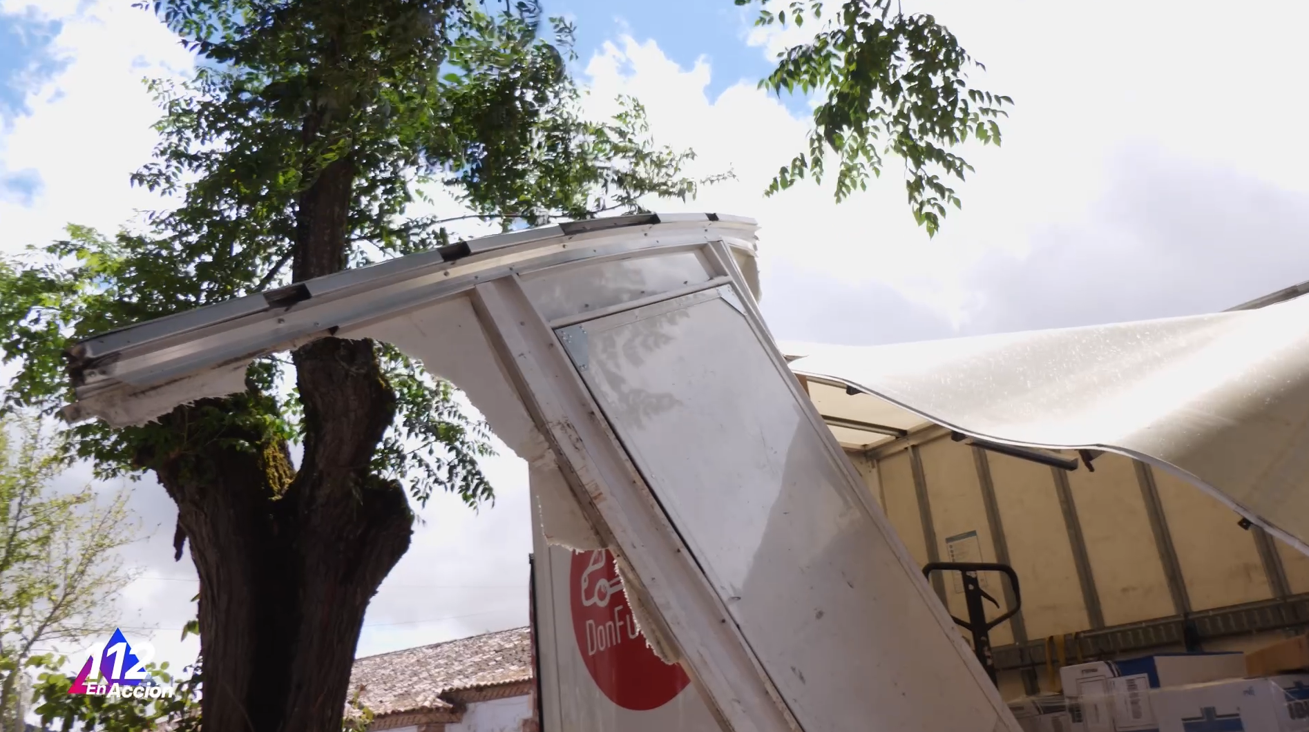 Camión de reparto con una rama incrustada en uno de los laterales de la caja de carga