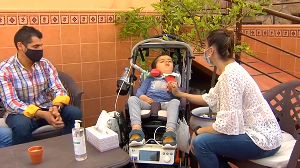 Alberto y sus padres sentados en la terraza de su casa