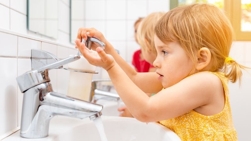 niña lavándose las manos