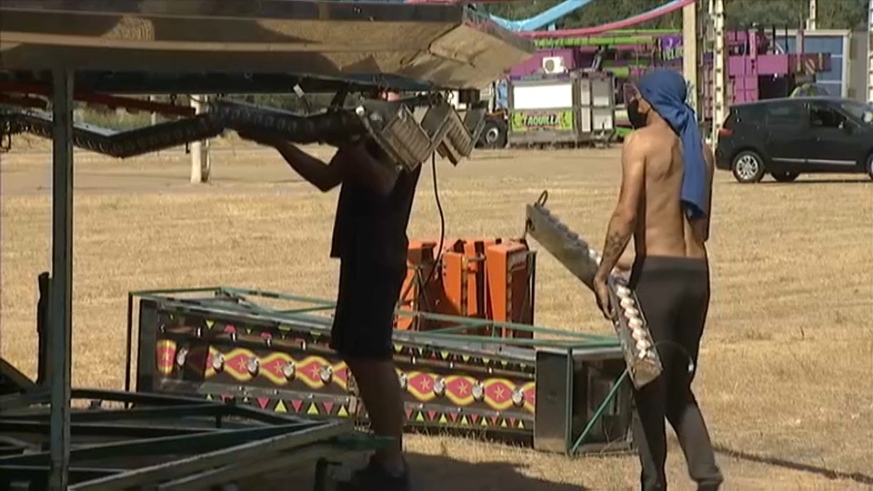 Feriantes montando las atracciones en el ferial de Caya en Badajoz.