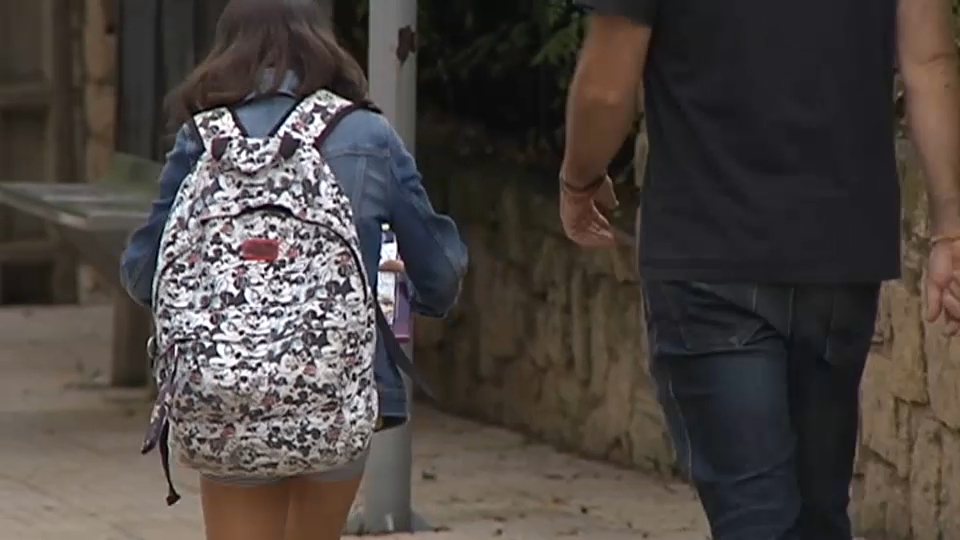 Padre e hija anónimos paseando por la calle
