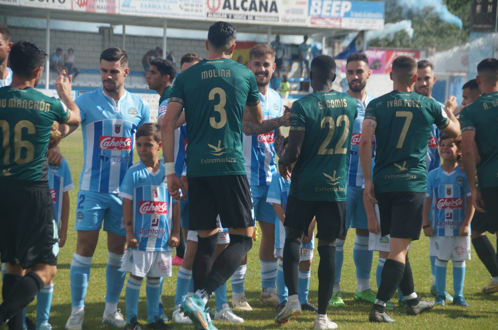 Los jugadores del Coria y del Cacereño se saludan antes del derbi en La Isla