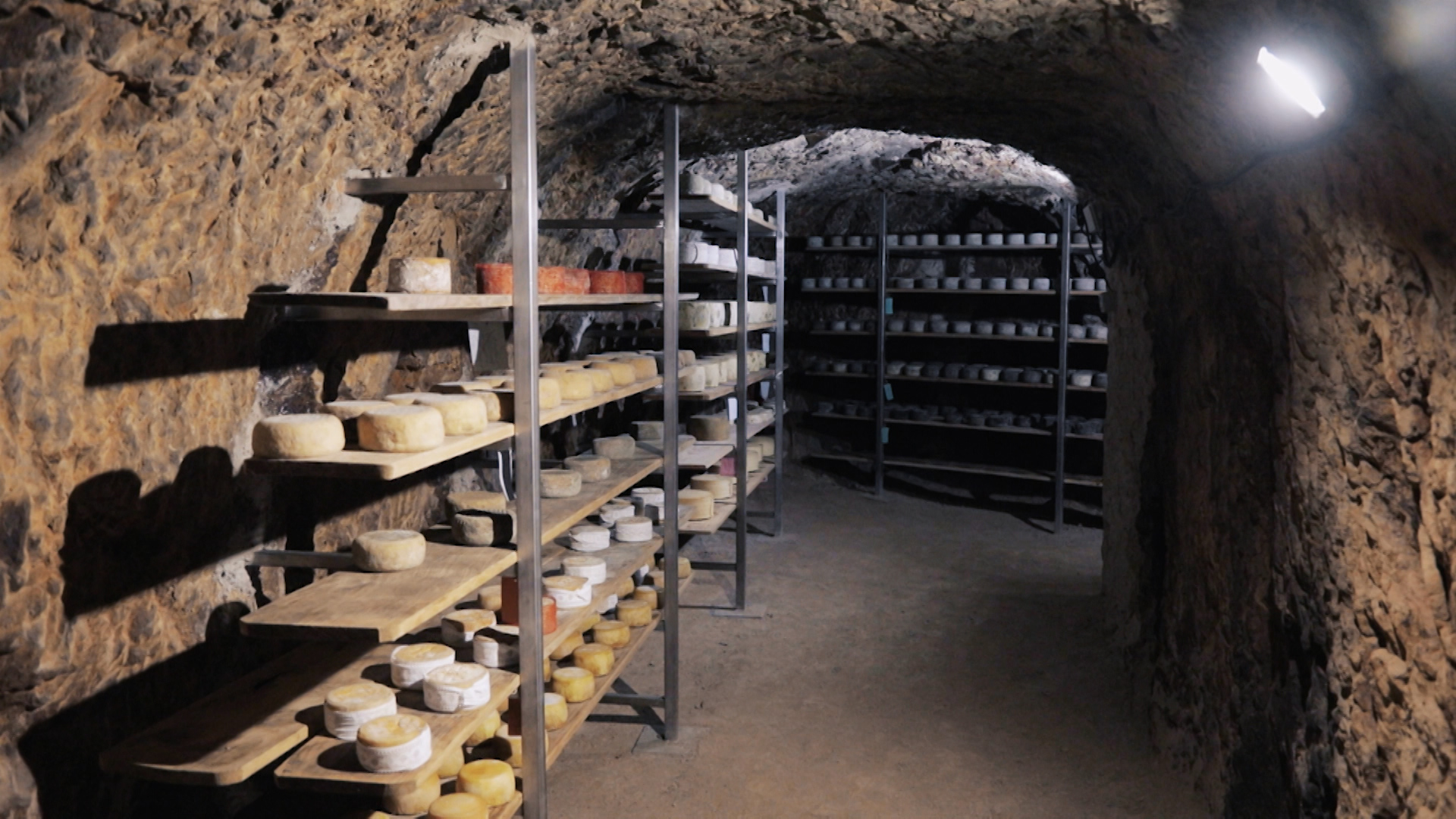 Cueva con quesos preparados para su afinación
