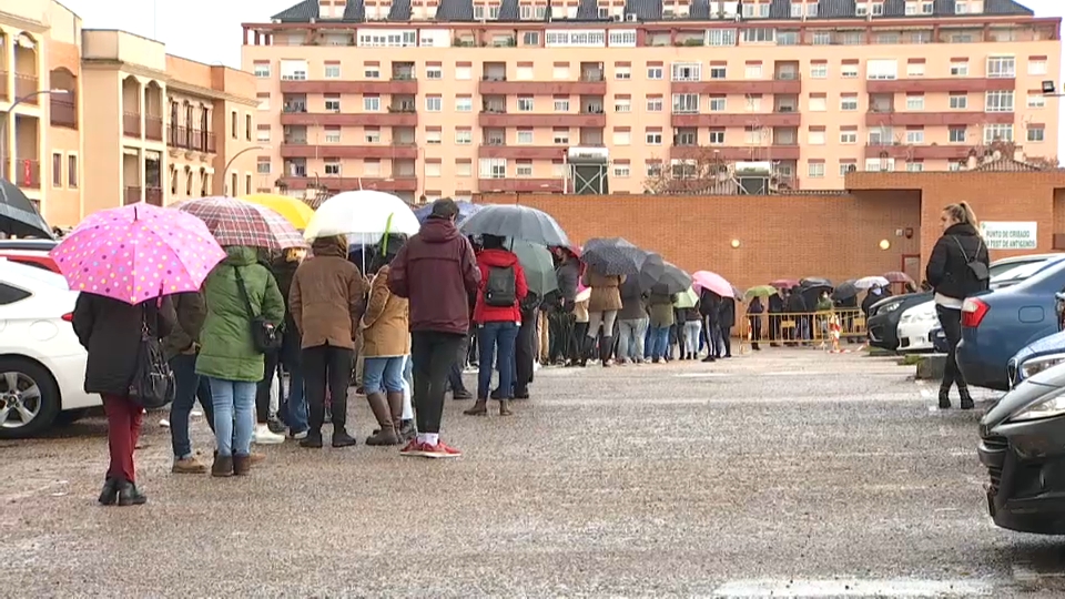 Pacenses haciendo cola bajo la lluvia en el punto de cribado