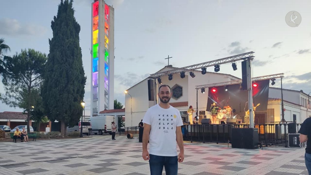 Jairo Pino, alcalde de Vivares, frente a la torre de la iglesia con la iluminación de los colores LGTBI