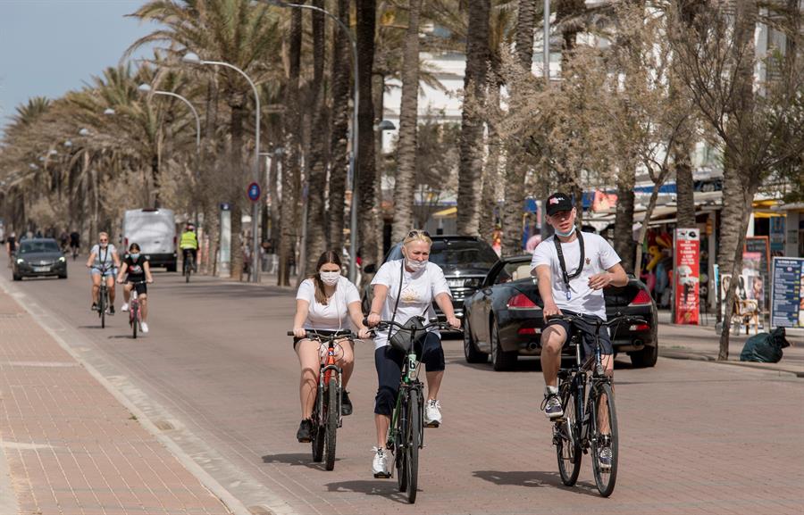 Turistas con mascarillas en la playa de Gandía