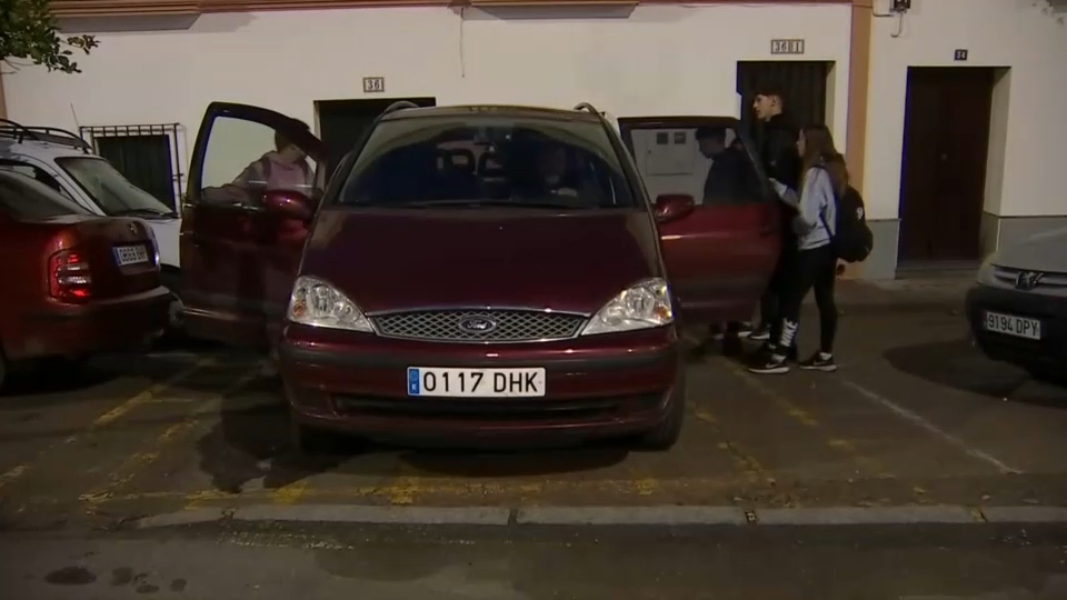 padres montando a sus hijos en el coche