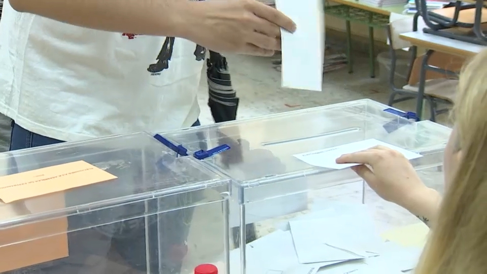 Una persona deposita su voto en una urna
