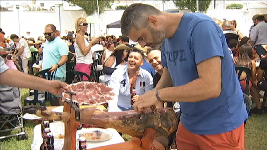Un hombre cortando jamón en la Fiesta del Jamón de Monesterio