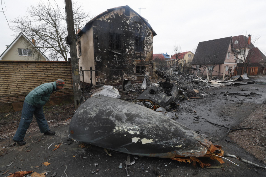 Un hombre mira los escombros de un avión militar que fue derribado durante la noche en Kiev, Ucrania, el 25 de febrero de 2022. Las tropas rusas ingresaron a Ucrania el 24 de febrero, lo que llevó al presidente del país a declarar la ley marcial.