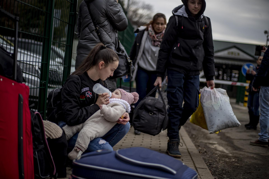 Una mujer alimenta a un niño mientras las personas que huyen de Ucrania llegan a Eslovaquia a través del cruce fronterizo de Ubla, el 25 de febrero de 2022. Eslovaquia dijo que permitirá que los ucranianos que huyen entren al país tras el paso de Rusia Operación militar en Ucrania.