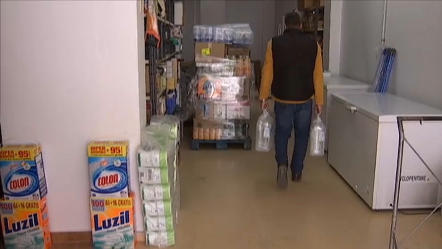 Dueño de tienda de alimentación vendiendo agua embotellada