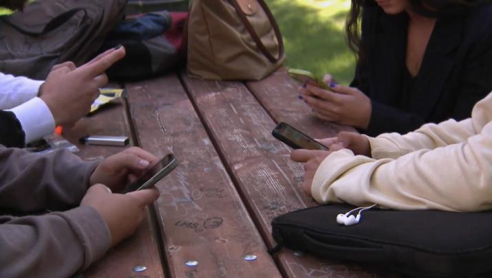 Jóvenes utilizando teléfonos móviles - Imagen de archivo.