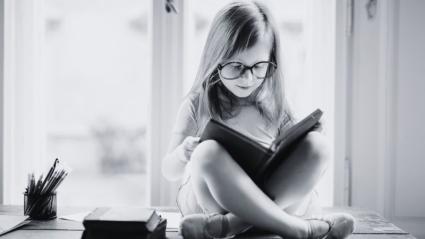 Niña leyendo un libro de texto