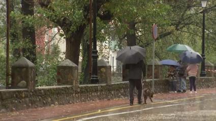 Personas paseando con paraguas durante la borrasca Claudia