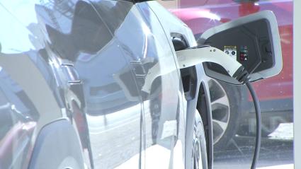 Un coche eléctrico cargándose dentro de un concesionario