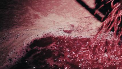 Vino tinto cayendo a un recipiente