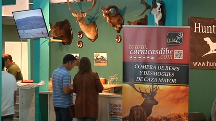 Stand de la Feria de la Caza, la Pesca y la Naturaleza Ibérica, con público y cabezas de animales. 